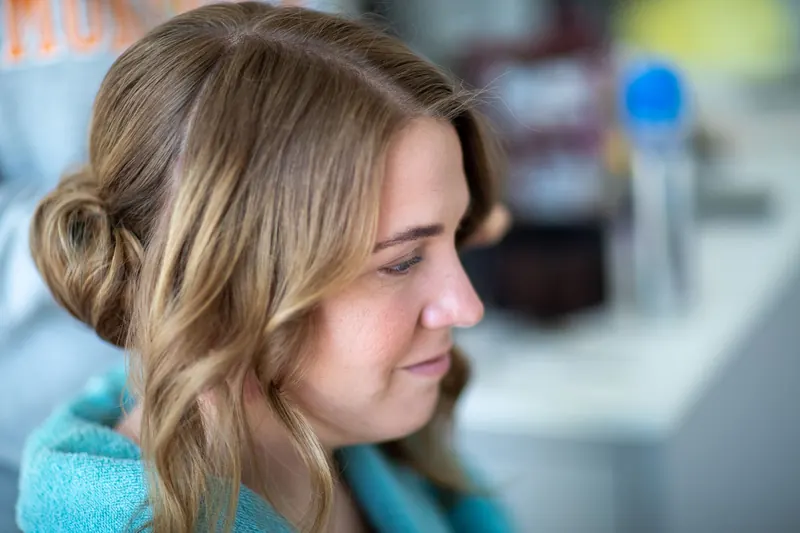 Profile view of a woman with styled hair in a casual indoor setting