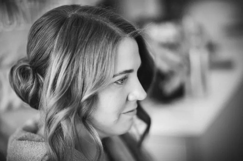 Stylish black and white portrait showcasing an elegant woman with curled hair in a serene expression